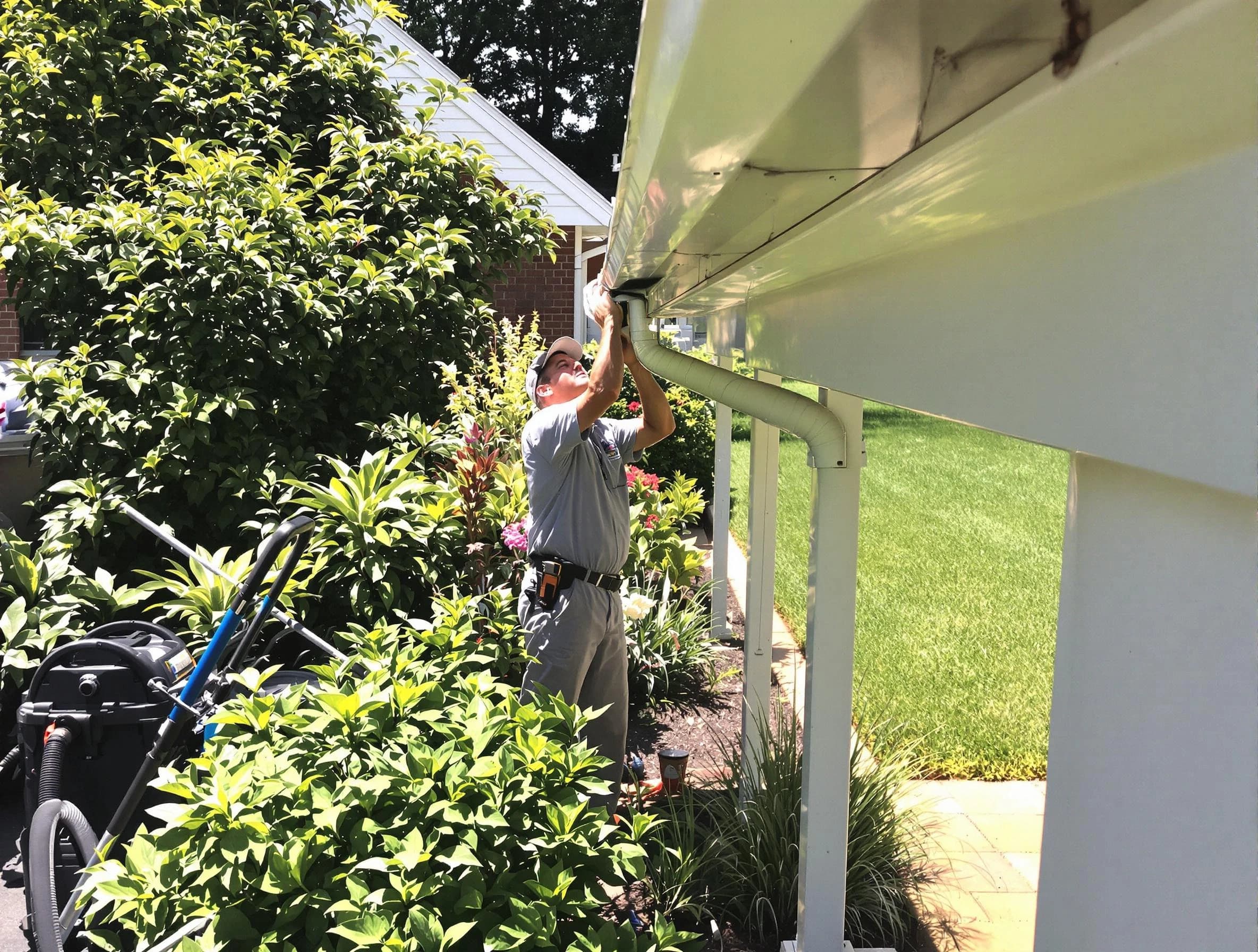 Technician flushing a blockage from a downspout in Shaker Heights, OH